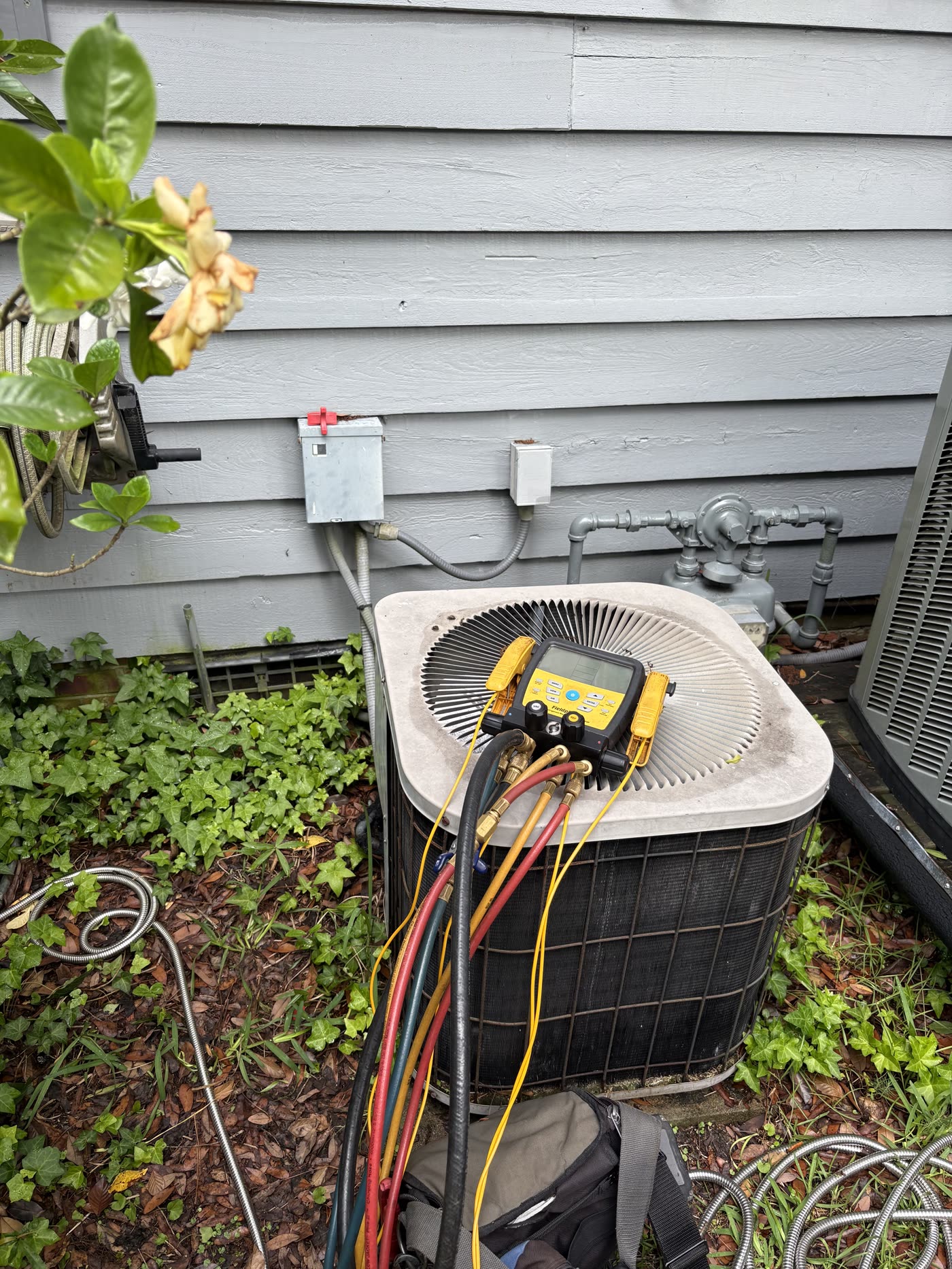 Manifold gauges connected to an outdoor unit during a service call